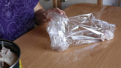 the cook puts pieces of chicken in a plastic sleeve. Video close-up, high quality