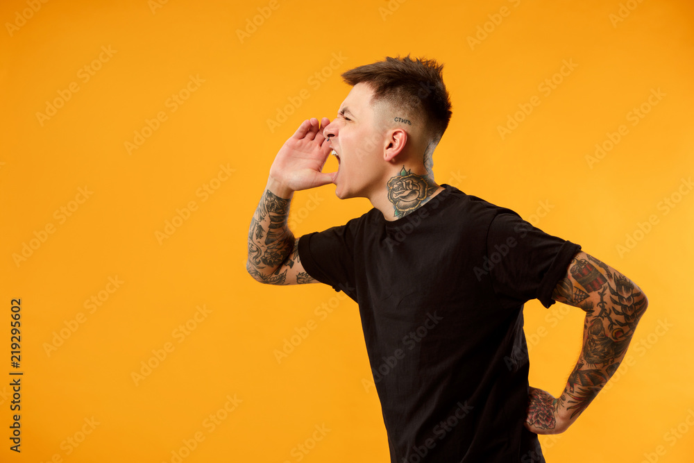 Do not miss. Young casual man shouting. Shout. Crying emotional man screaming on studio background. male half-length portrait. Human emotions, facial expression concept. Trendy colors Do not miss. Young casual man shouting. Shout. Crying emotional man screaming on studio background. male half-length portrait. Human emotions, facial expression concept. Trendy colors