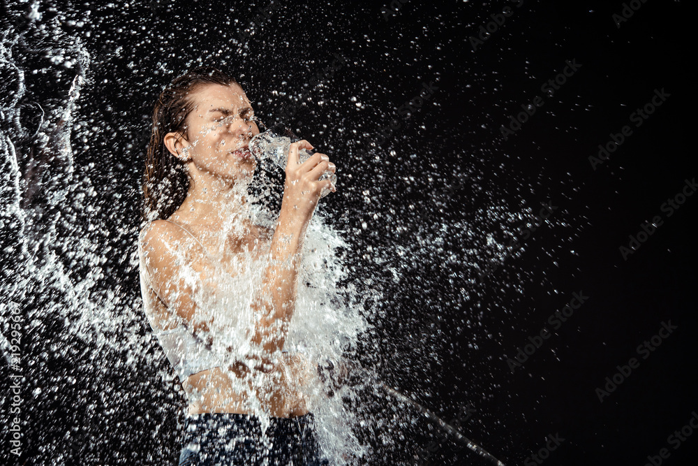 Obraz premium side view of woman swilled with water while drinking water from glass isolated on black