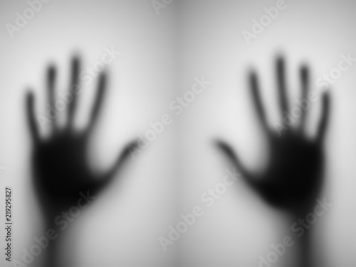 blurred of a hand behind matted glass.