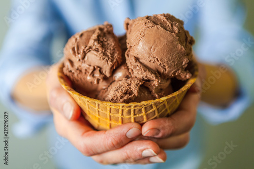 Closeup of Hands Holding a Waffle Bowl with Chocolate Ice Cream