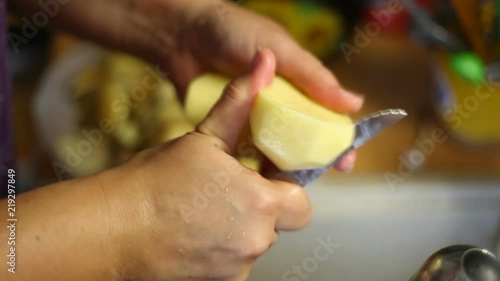 The chef cleans the potatoes with a knife. Video close-up, high quality