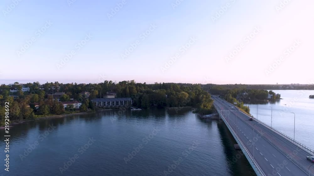 4K Aerial cool blue scene drone flying towards above sea, bridge with driving cars beside on a summer evening around sunset. Lauttasaari, Länsiväylä, Lapinlahti bridge, Helsinki, Finland, Scandinavia. 4K Aerial cool blue scene drone flying towards above sea, bridge with driving cars beside on a summer evening around sunset. Lauttasaari, Länsiväylä, Lapinlahti bridge, Helsinki, Finland, Scandinavia.
