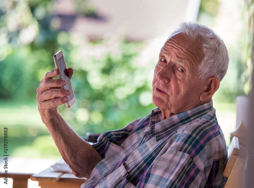 Fototapeta premium Old man talking on mobile phone