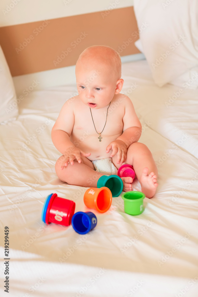 Cute little baby boy playing with stacking cups Cute little baby boy playing with stacking cups