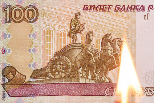 Symbol of inflation. Russian crisis: fall of rus rubles. Currency depreciation. Money concept. 100 ruble and burning match