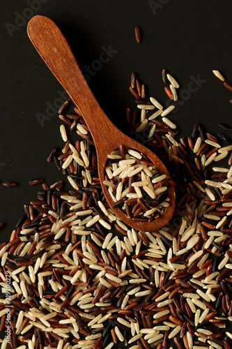 Mixed rice of unmilled rice grains on the black background. photo