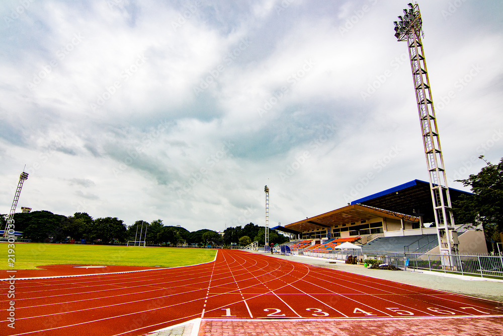 Obraz premium Red running track in the stadium.white line and Green lawn