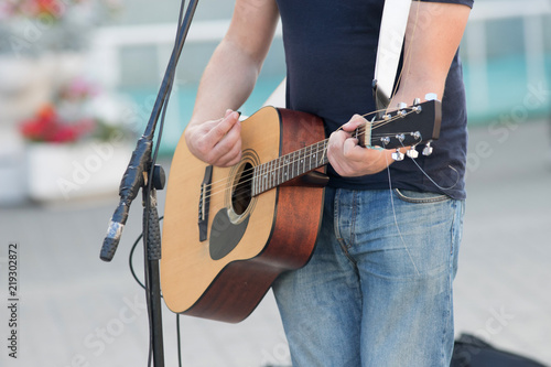 Anonymous man playing guitar on the street, street musician photo