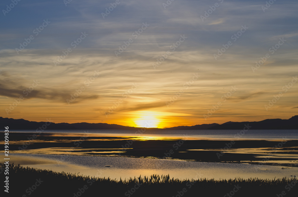 A grand paint like colorful blue and yellow sunset at the great salt lake in utah.