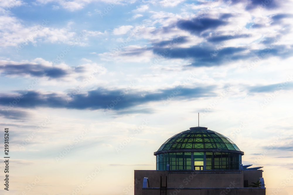 Fototapeta premium Glass dome of a building against a background of the evening cloudy sky.