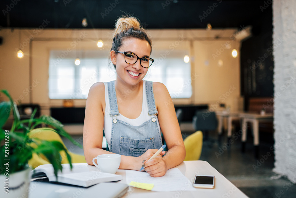 Portrait of a smiling female preparing for the exam in public place. Portrait of a smiling female preparing for the exam in public place.