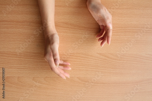 beautiful female hand on wood table background.