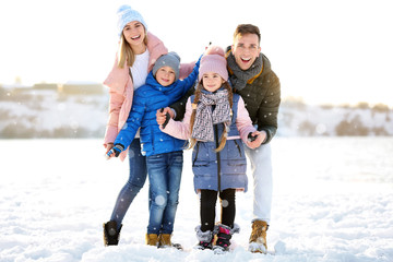 Portrait of happy family outdoors on winter day
