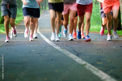 Closeup feet group athletes running marathon in woods