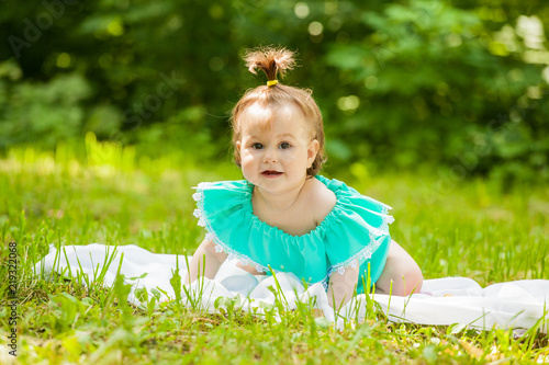 little girl in a dress sitting on a juicy green grass