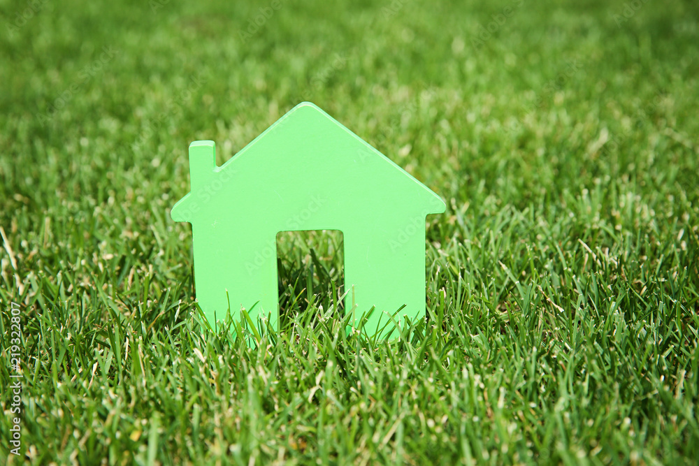 House model on green lawn. Real estate agent concept House model on green lawn. Real estate agent concept
