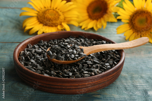 Bowl and spoon with sunflower seeds on table, closeup © New Africa