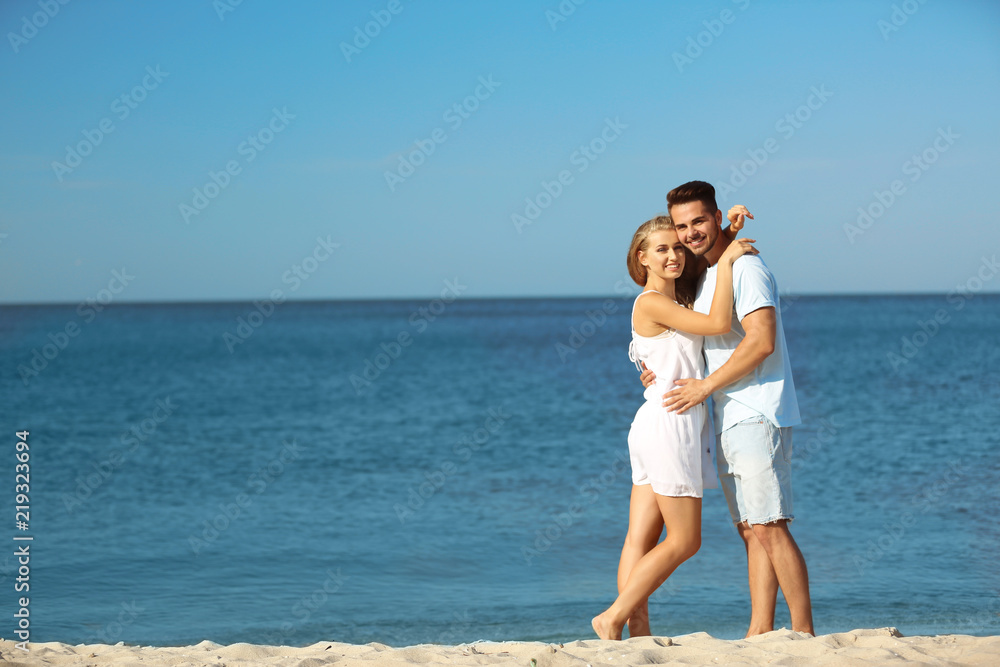 Happy young couple at beach on sunny day