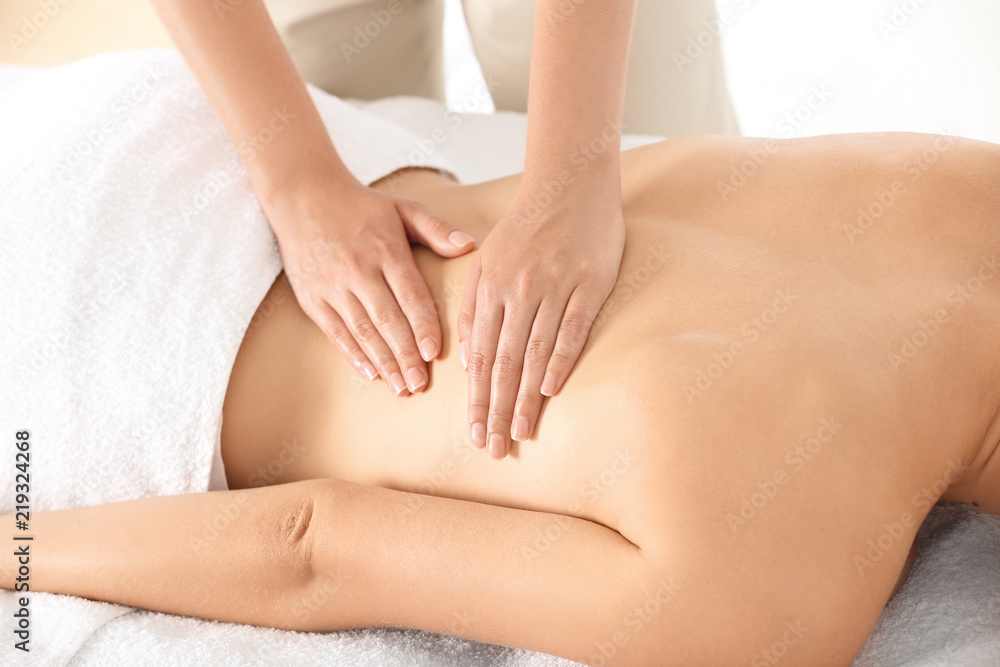 Relaxed woman receiving back massage in wellness center