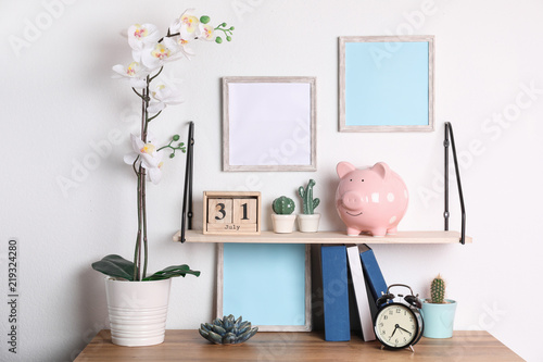 Color piggy bank on shelf over table in room. Cute interior element © New Africa