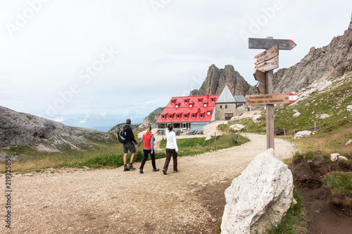 Three hikers visiting to a hut on mountain Sciliar photo