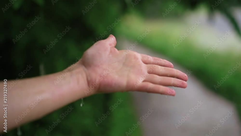 Hand of a young unrecognizable woman with long fingernails under the rain touching the water. Summer. Concept of being calm and enjoying the weather. Loving nature. Handheld slow motion medium shot Hand of a young unrecognizable woman with long fingernails under the rain touching the water. Summer. Concept of being calm and enjoying the weather. Loving nature. Handheld slow motion medium shot