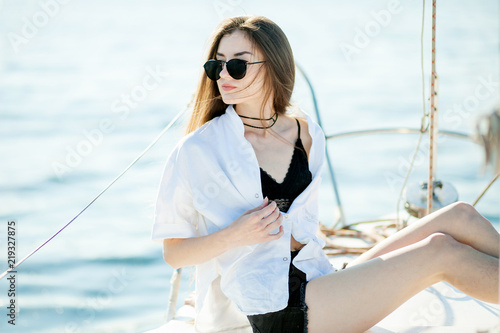 Girl sitting on the bow of a sailboat, ship © Smeilov