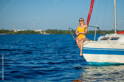 Girl sitting on the bow of the yacht, sailboat © Smeilov