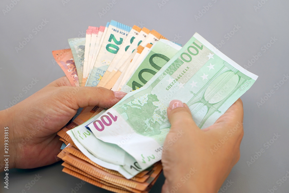Woman hands that consider 100, 50-euro bills. In the hands of a lot of money, denominations of euros. Businesswoman hands hold and counting euro banknotes. Woman hands that consider 100, 50-euro bills. In the hands of a lot of money, denominations of euros. Businesswoman hands hold and counting euro banknotes.