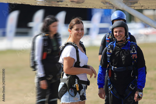 Dziewczyna i chłopak przed wejściem do samolotu ze spadochronami.