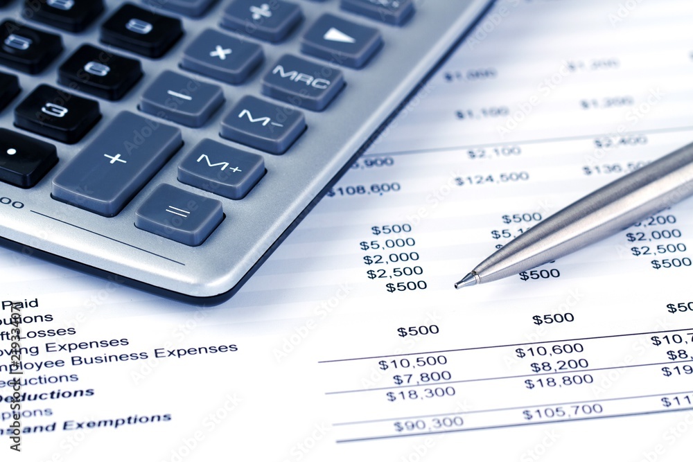 Calculator and pen on top of financial documents Calculator and pen on top of financial documents
