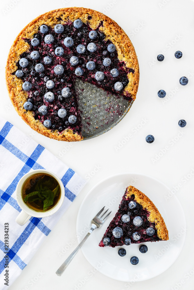 Slice of pie with black currant and blueberries and a cup of tea