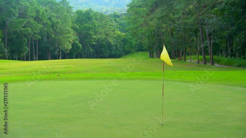 Beautiful golf course on mountain, fairway and layout beauty in forest. Flag on green golf.
