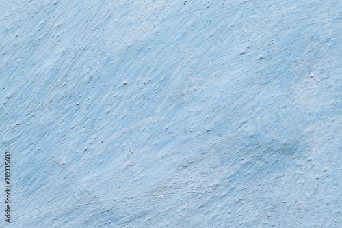 Aged adobe whitewashed wall in light-blue color, retro background, detailed texture photo