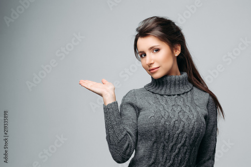 Photos Waist up portrait of beautiful girl showing empty copy space in left side