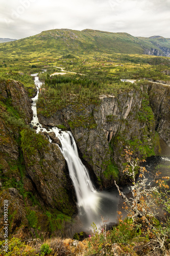 Beautiful view of the Voringsfossen waterfall. Bjoreio river . National park Hardangervidda, Eidfjord, Norway. Summer landscape in the mountains with a waterfall and fog. Foggy weather in the mountain photo