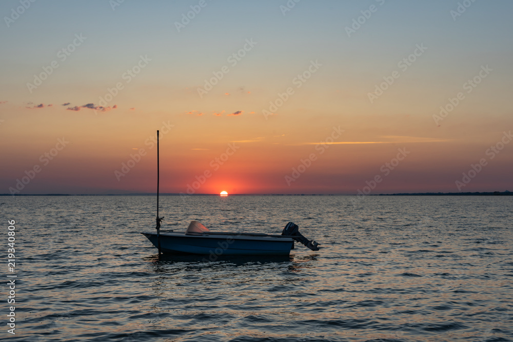 lever de soleil sur un étang avec un bateau en silhouette