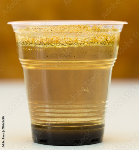 Dirty water, through filtration after cleaning on a plastic cup