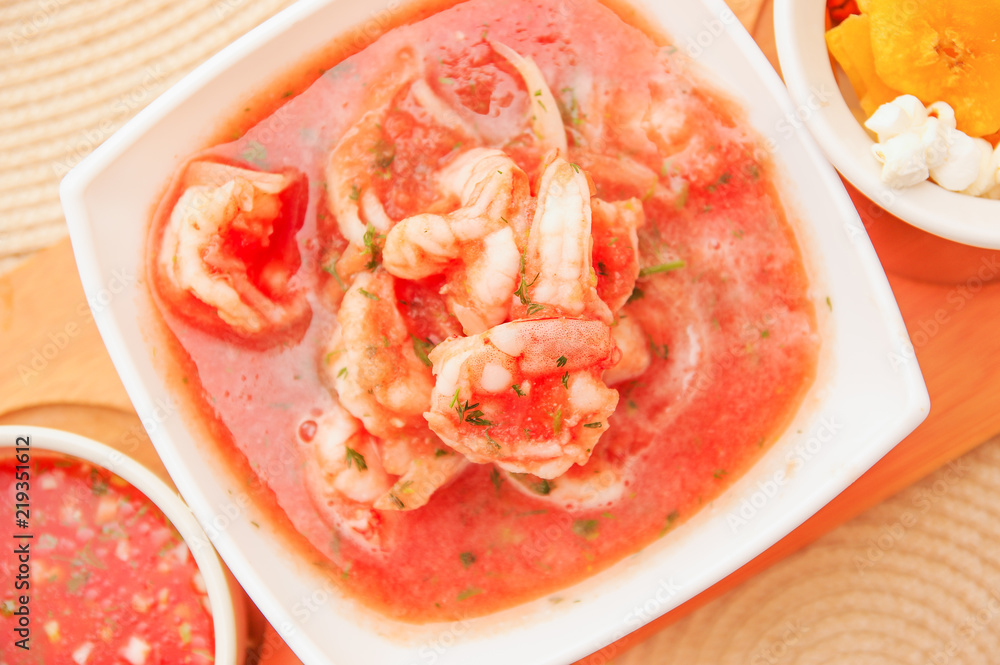 Above view of typical Ecuadorian food: shrimp cebiche inside of rectangular bowl in a blurred background
