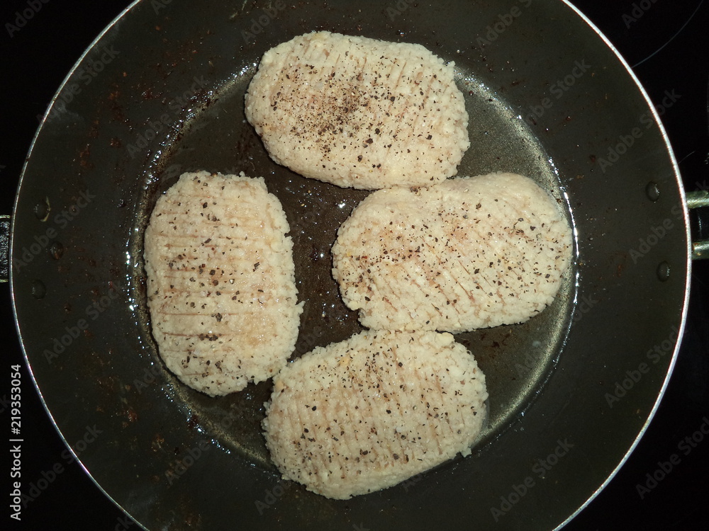 prepared for roasting chicken cutlets with spices in a frying pan