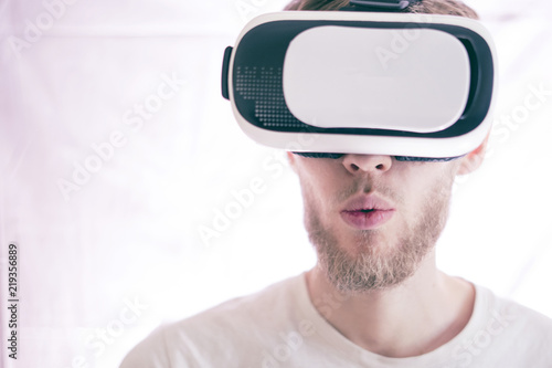 young emotional man using vr glasses playing the video virtual games isolated