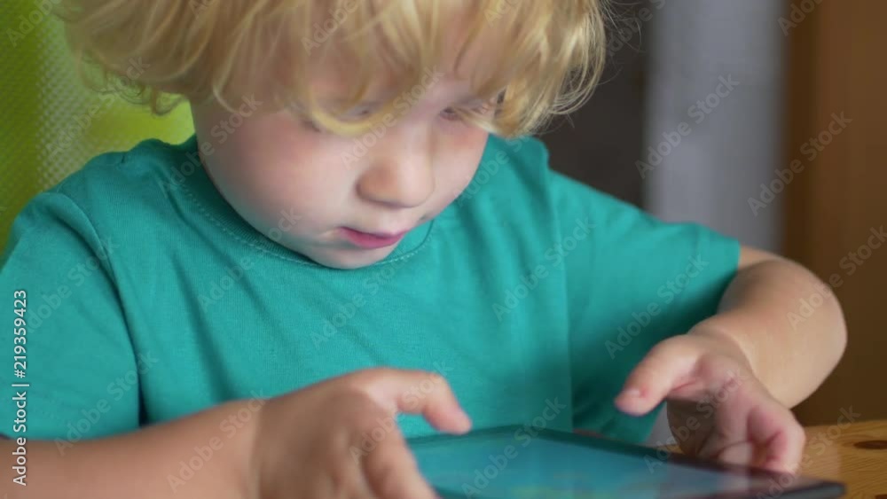 Close up of the child boy playing with digital tablet Close up of the child boy playing with digital tablet