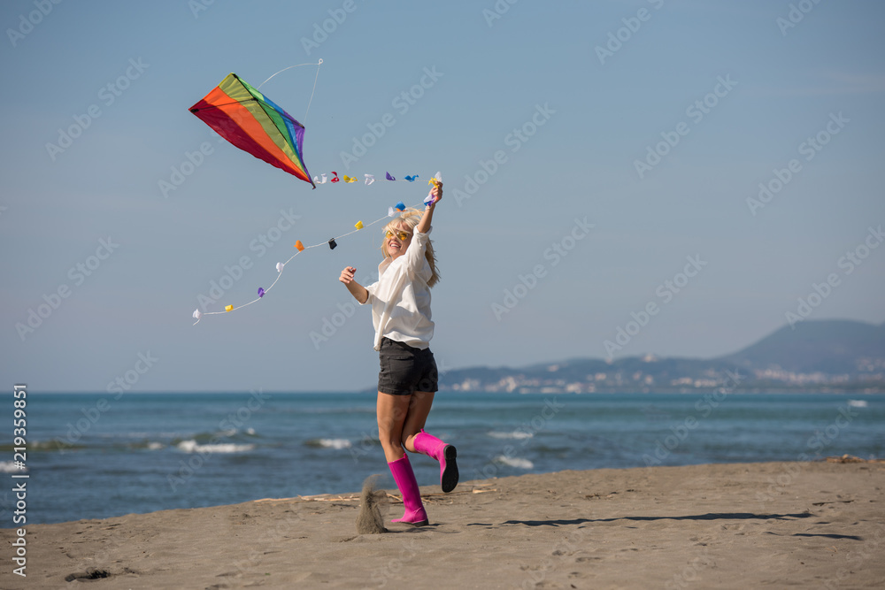 Young Woman with kite at beach on autumn day