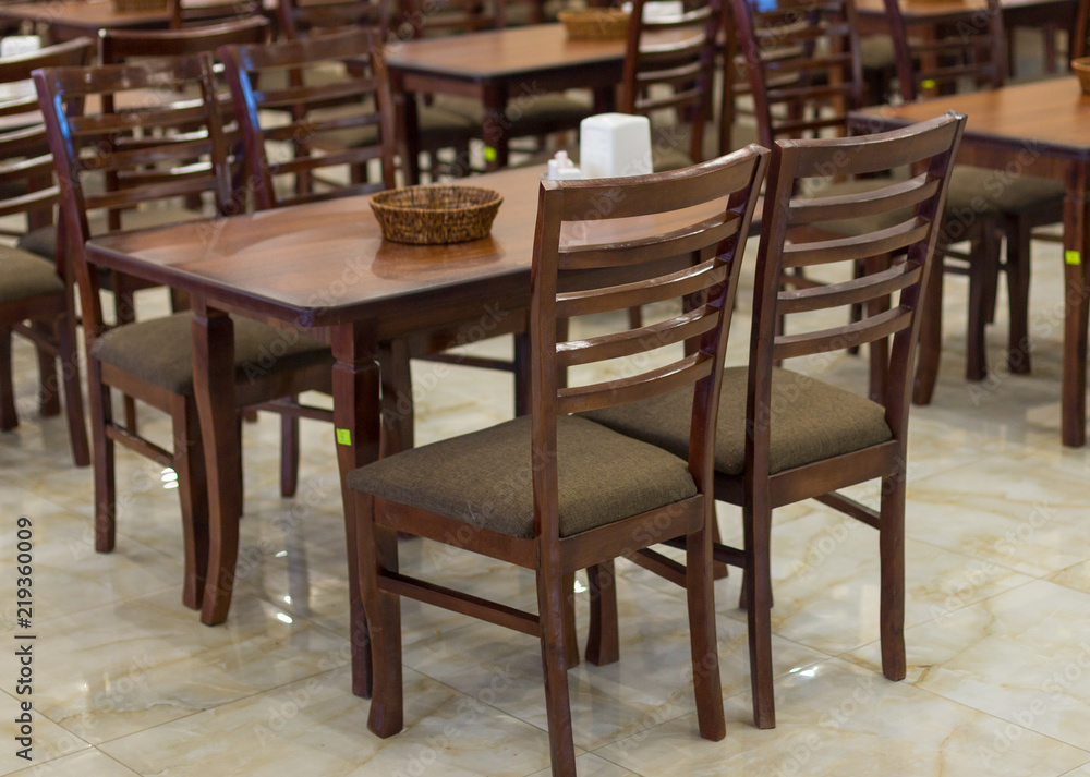 a lot of wooden, brown chairs in a cafe