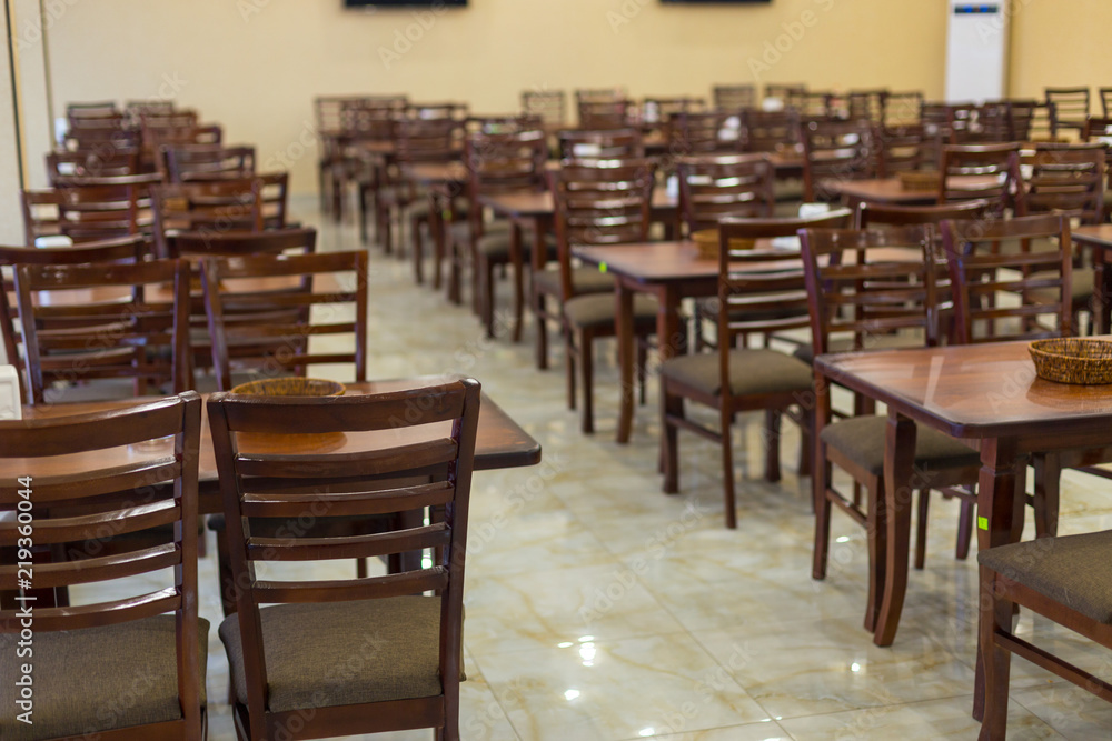 a lot of wooden, brown chairs in a cafe a lot of wooden, brown chairs in a cafe