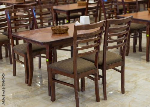 a lot of wooden  brown chairs in a cafe