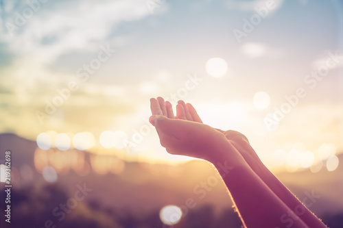 Fototapeta Woman hands place together like praying in front of nature green  background