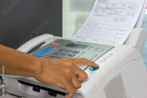 Fototapet Hand man are using a fax machine in the office. Business concept