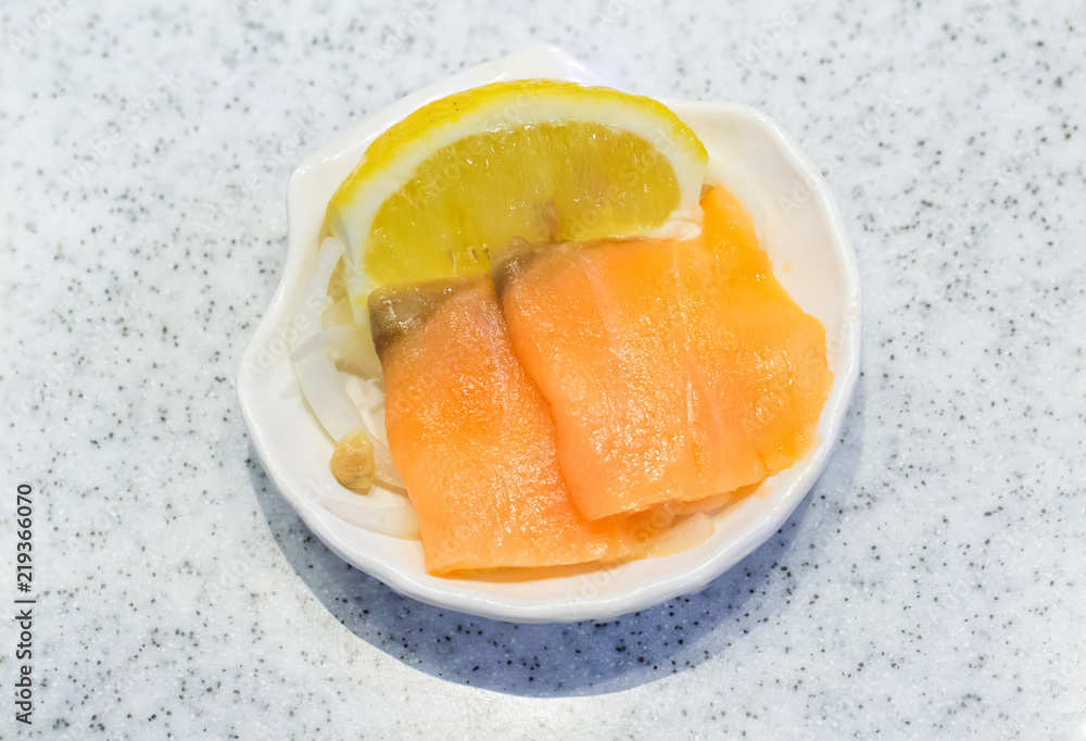 salmon on plate. Smoked salmon on dishware with bright background. smoked salmon with lemon slices on white plate